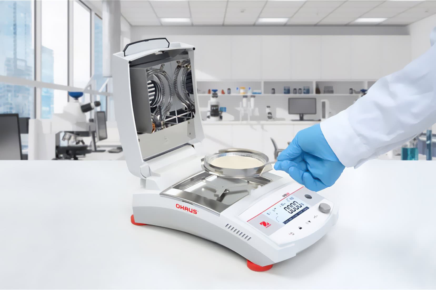 Laboratorium met Ohaus MB32 vochtigheidsanalyser, open deksel, gehandschoende hand stelt apparaat in. Laboratoriumomgeving, microscoop op de achtergrond, wit en blauw overheersen.