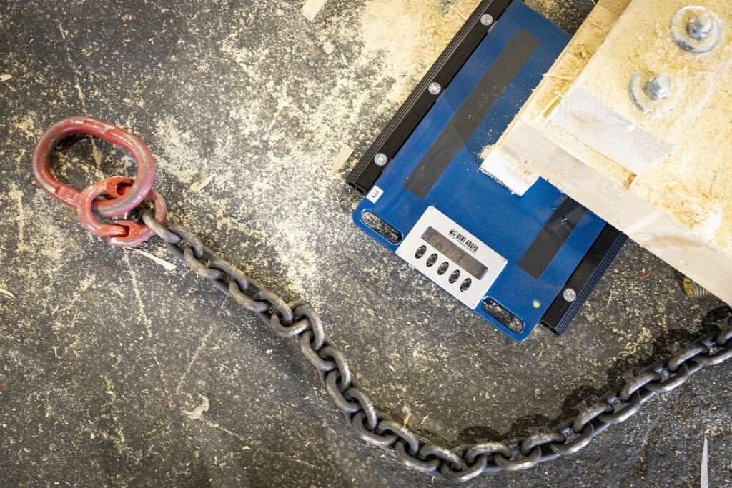 Rote Schäkel und Kette an Maschine in Werkstatt