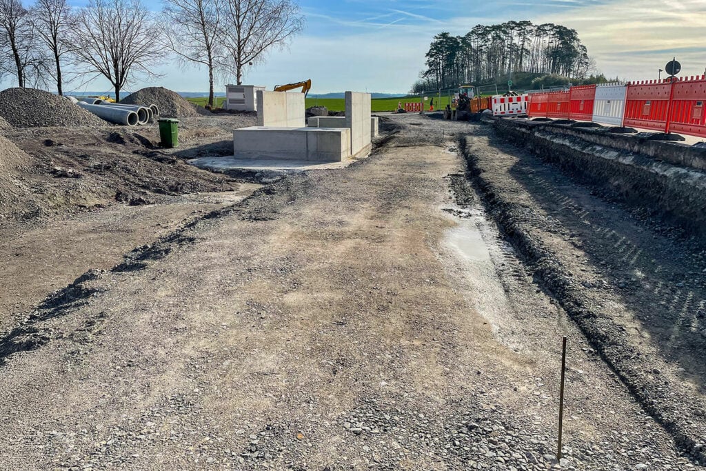 Bouwplaats met bouwmaterialen en graafmachine
