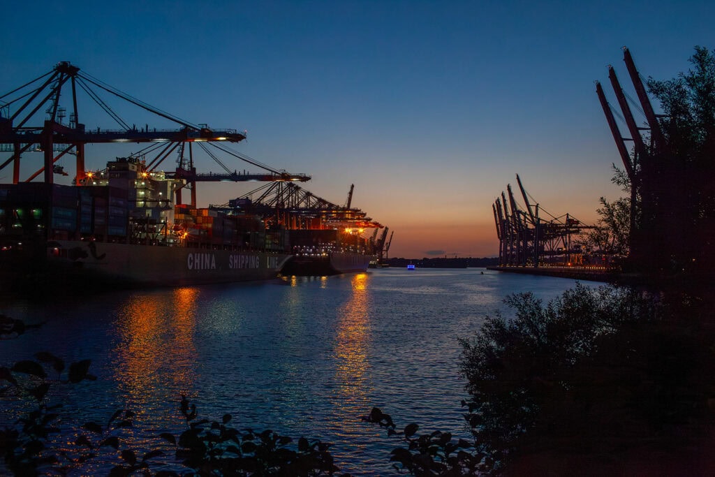 Frachtschiff bei Nacht im beleuchteten Hafen
