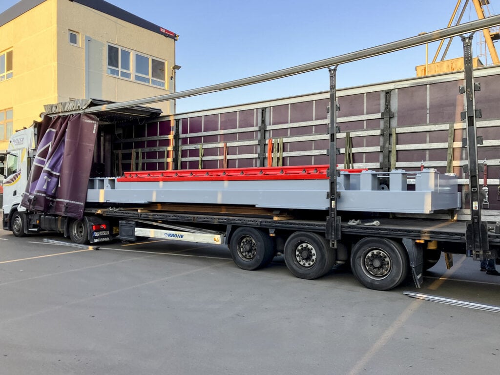 LKW lädt Gleiswaage bei Baustelle ab