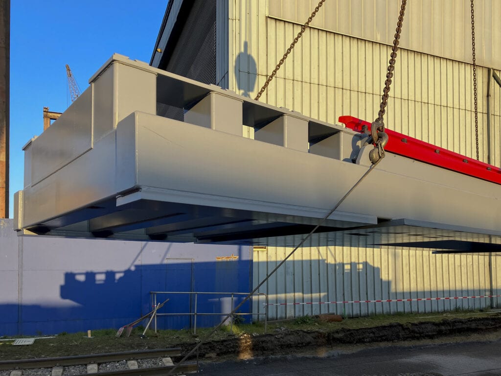 Kran hebt große Betonstruktur an Baustelle