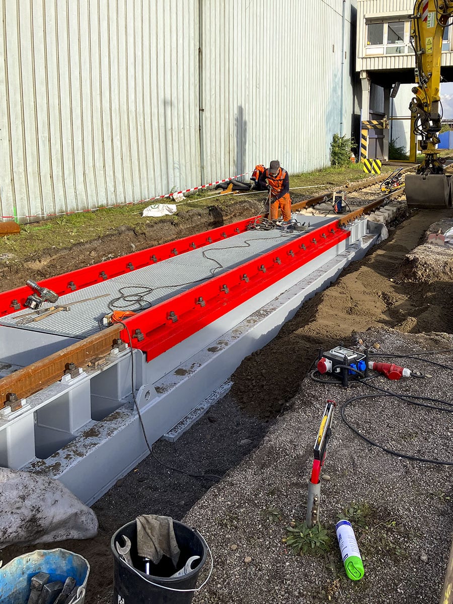 Construction worker installs large metal structure outdoors