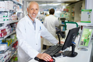 Apotheker lächelt hinter Theke in Apotheke