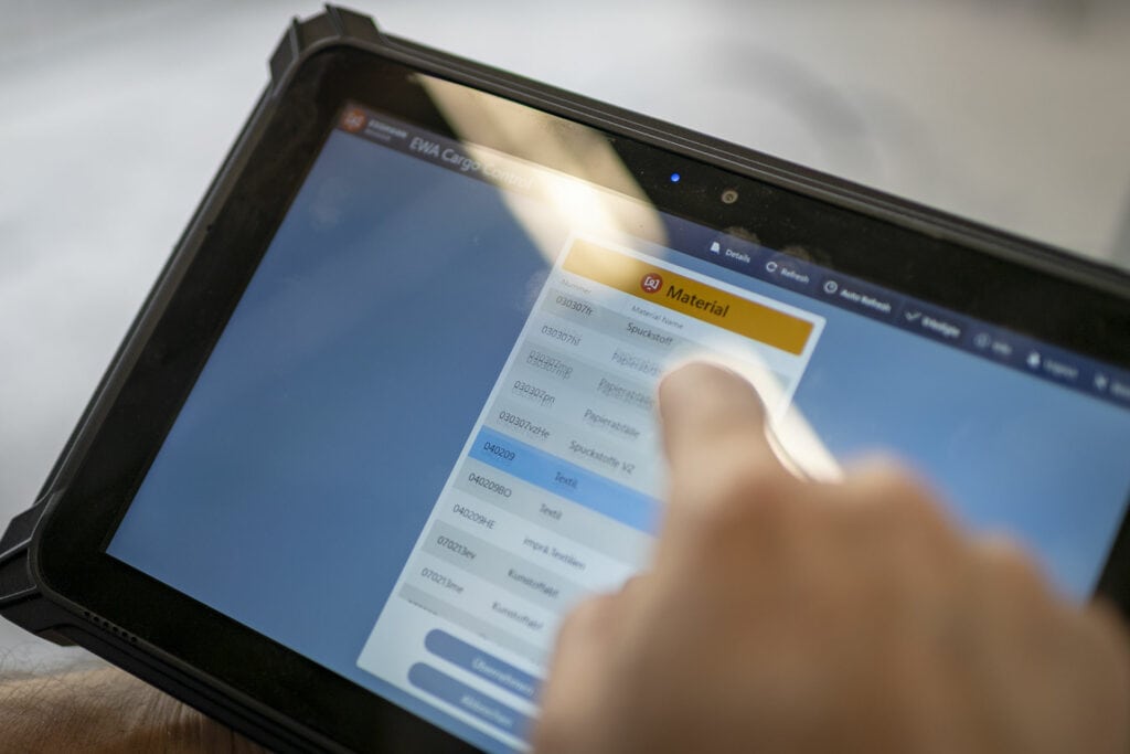 Person benutzt Materialverwaltungs-App auf Tablet