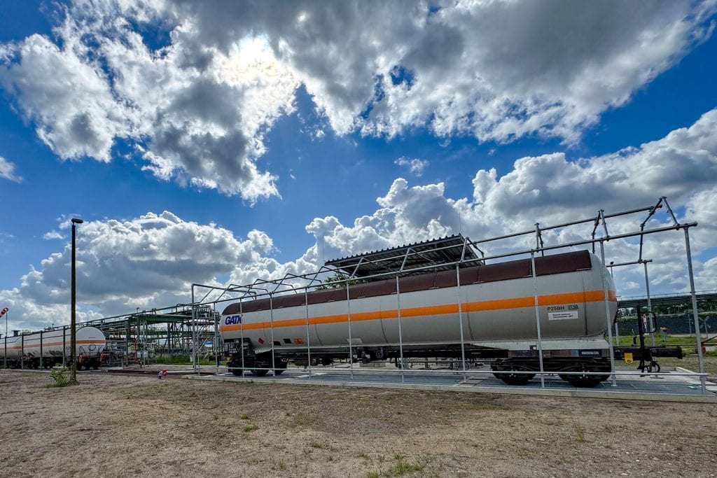 Kesselwagen in Industrieanlage unter dramatischem Himmel