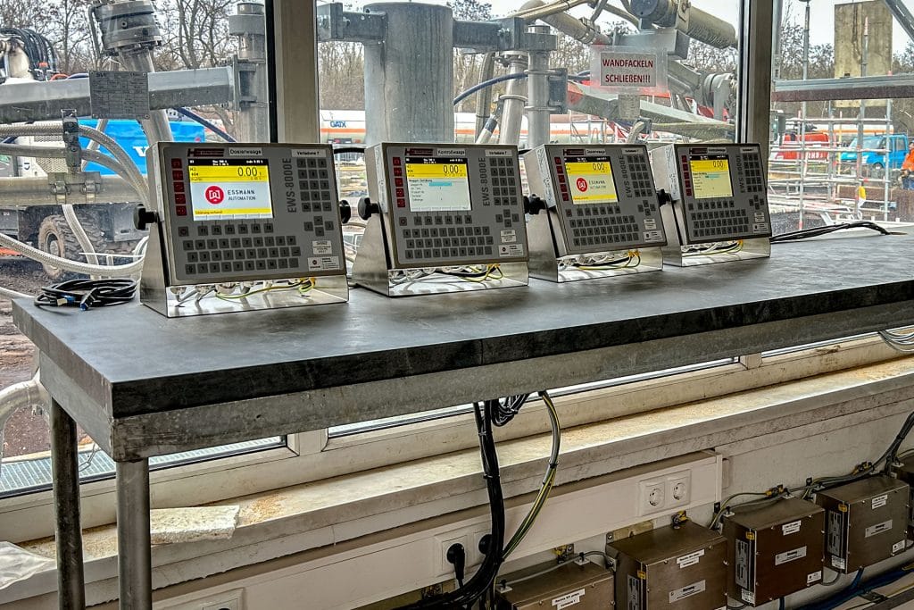 Vier industrielle Steuergeräte auf Metalltisch am Fenster