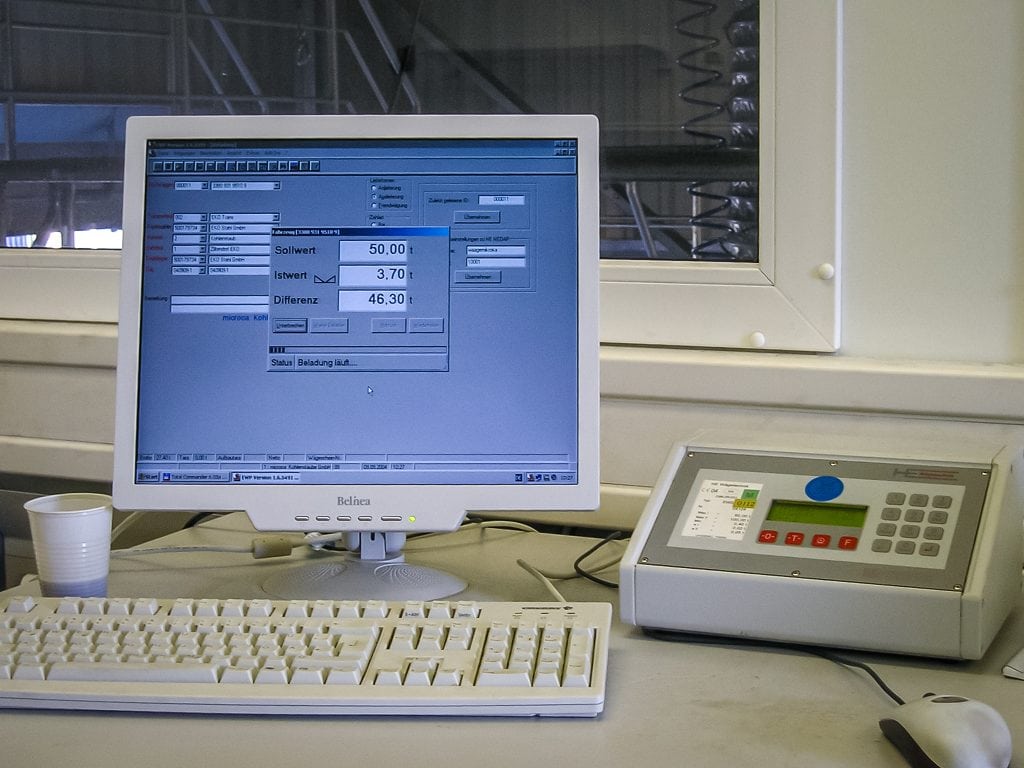 Büroarbeitsplat: ESSMANNs EWP Wägesoftware auf einem alten Monitor. Daneben eine alte EWS. Das Foto ist aus den frühen 2000ern.