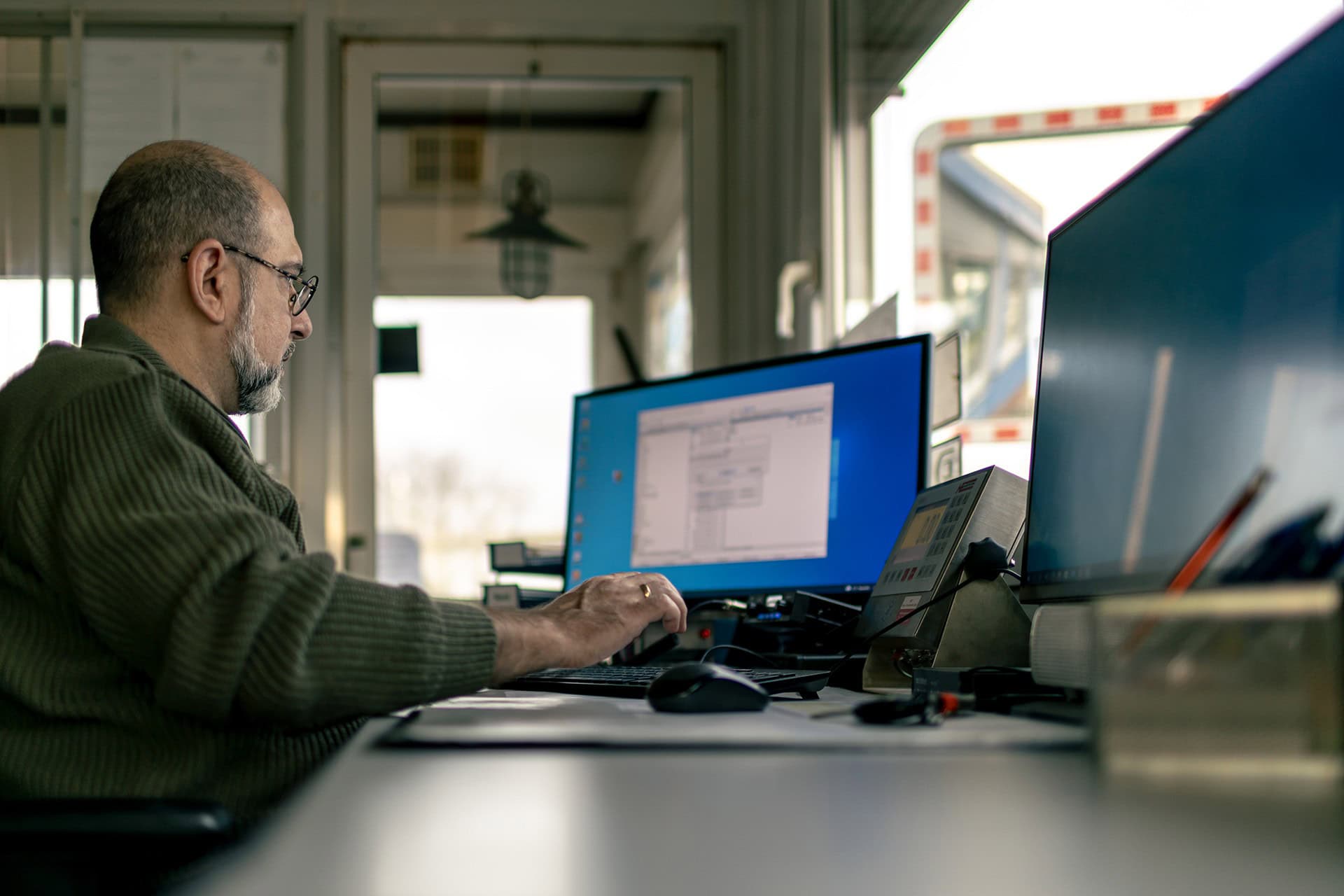 Mann mit Brille arbeitet konzentriert am Bürocomputer