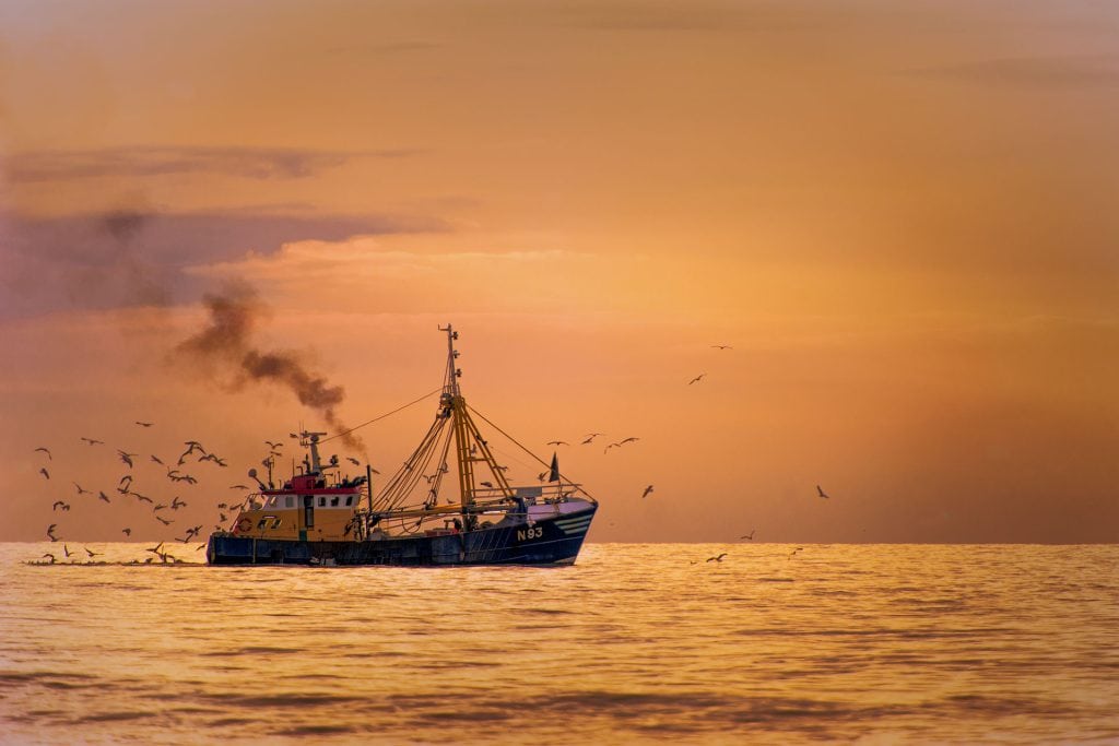Vissersboot N93 op zee bij een gouden zonsondergang